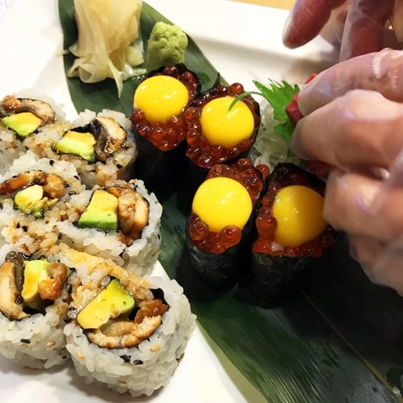 chef preparing sushi rolls