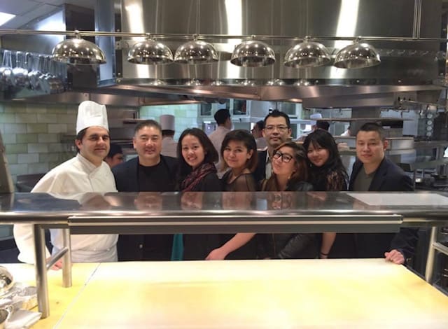 A group of people standing in front of an oven.